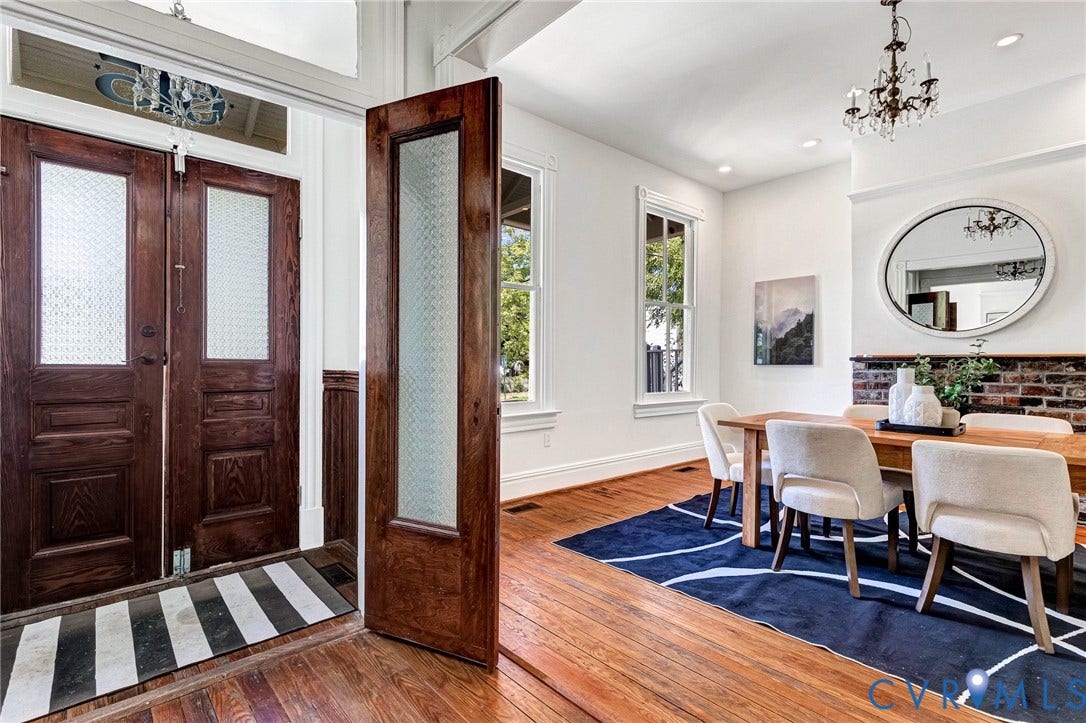 615 N 23rd Street, Church Hill Central, Richmond, VA 23223 Hardwood flooring, double entry doors with privacy glass, transom window, exposed brick detailing, and a chandelier