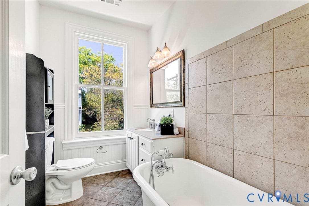 615 N 23rd Street, Church Hill Central, Richmond, VA 23223 White pedestal bathtub with chrome fixtures, tiled wall surround, and a vanity with an undermount sink