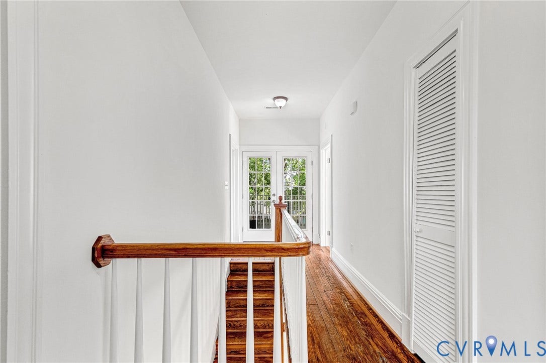 615 N 23rd Street, Church Hill Central, Richmond, VA 23223 Hardwood flooring, painted white walls, wood handrail, white balusters, and white louvered doors