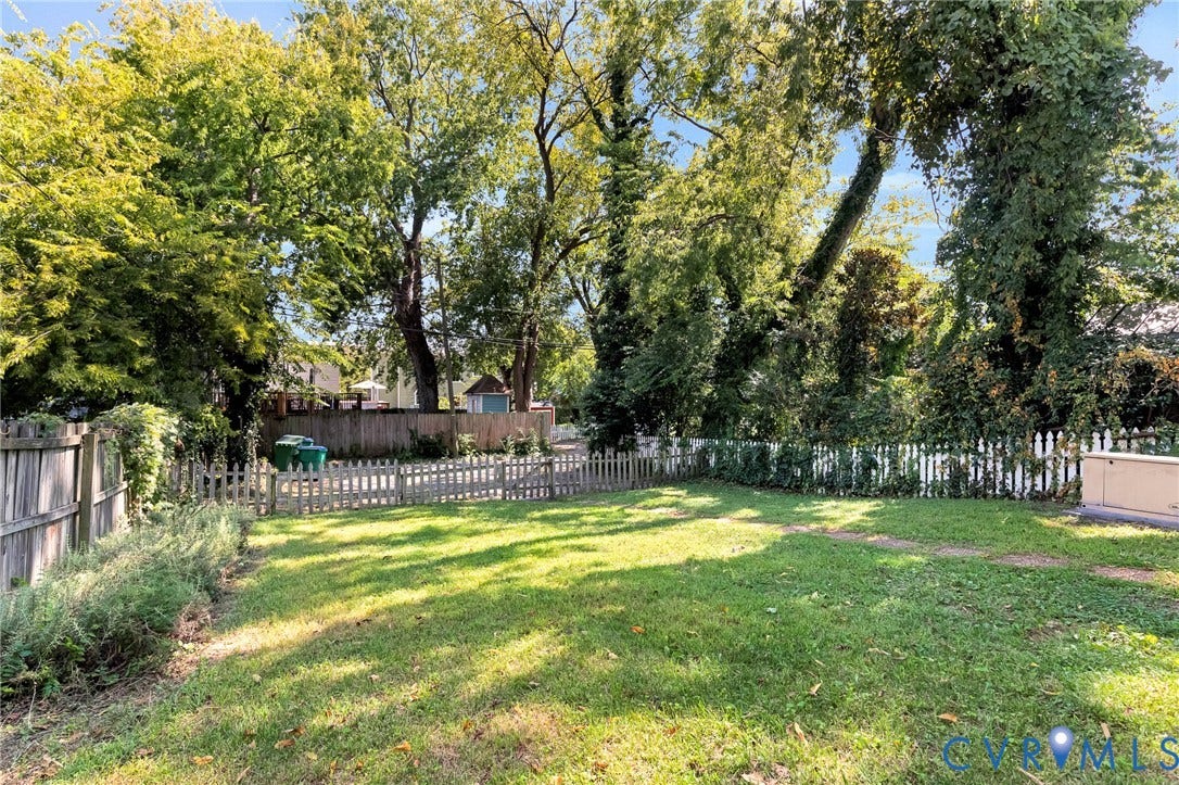 615 N 23rd Street, Church Hill Central, Richmond, VA 23223 Expansive backyard featuring a manicured lawn, established trees, and perimeter fencing