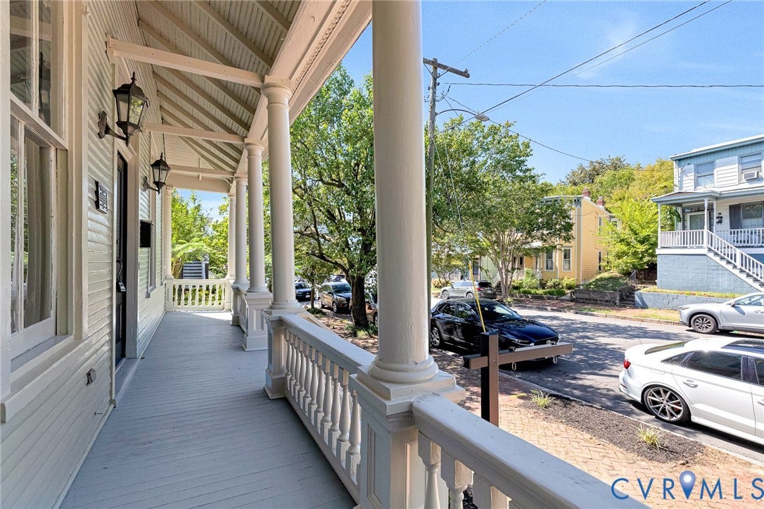615 N 23rd Street, Church Hill Central, Richmond, VA 23223 Expansive covered porch featuring turned columns, decorative railings, and wall-mounted lanterns