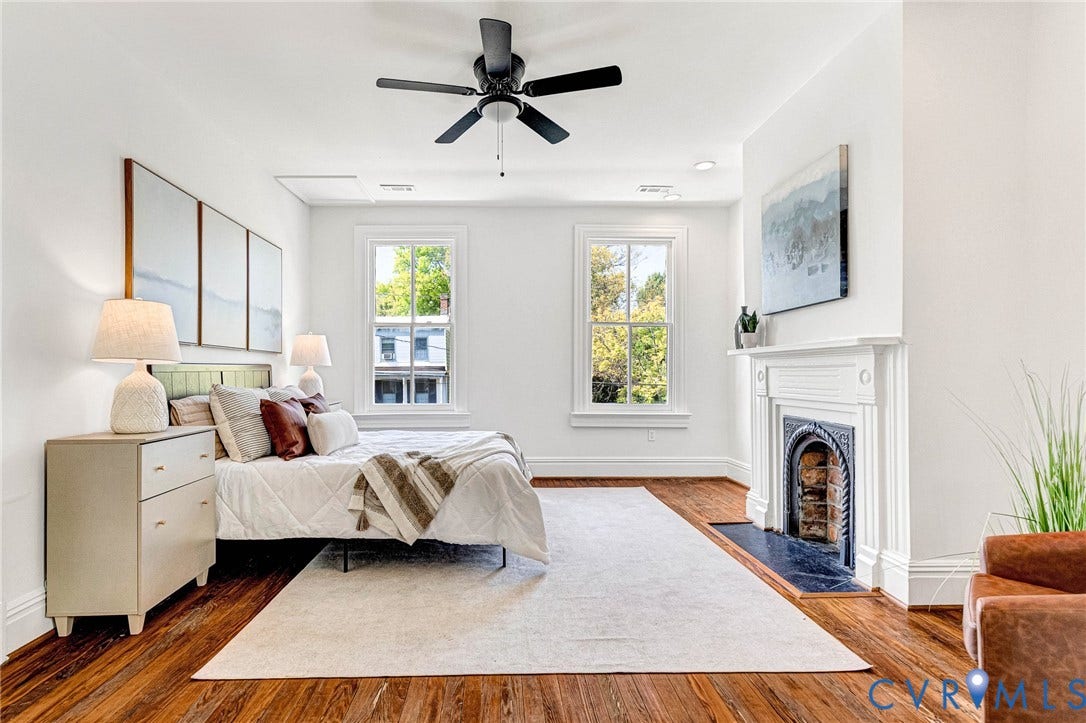 615 N 23rd Street, Church Hill Central, Richmond, VA 23223 Hardwood flooring, classic white window trim, white fireplace with decorative cast iron insert, black ceiling fan, and white painted walls