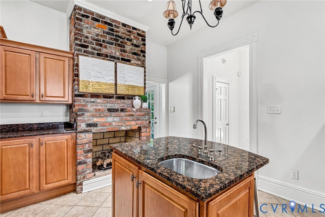 615 N 23rd Street, Church Hill Central, Richmond, VA 23223 Kitchen island with an undermount sink, granite countertop, and wood-finish cabinetry