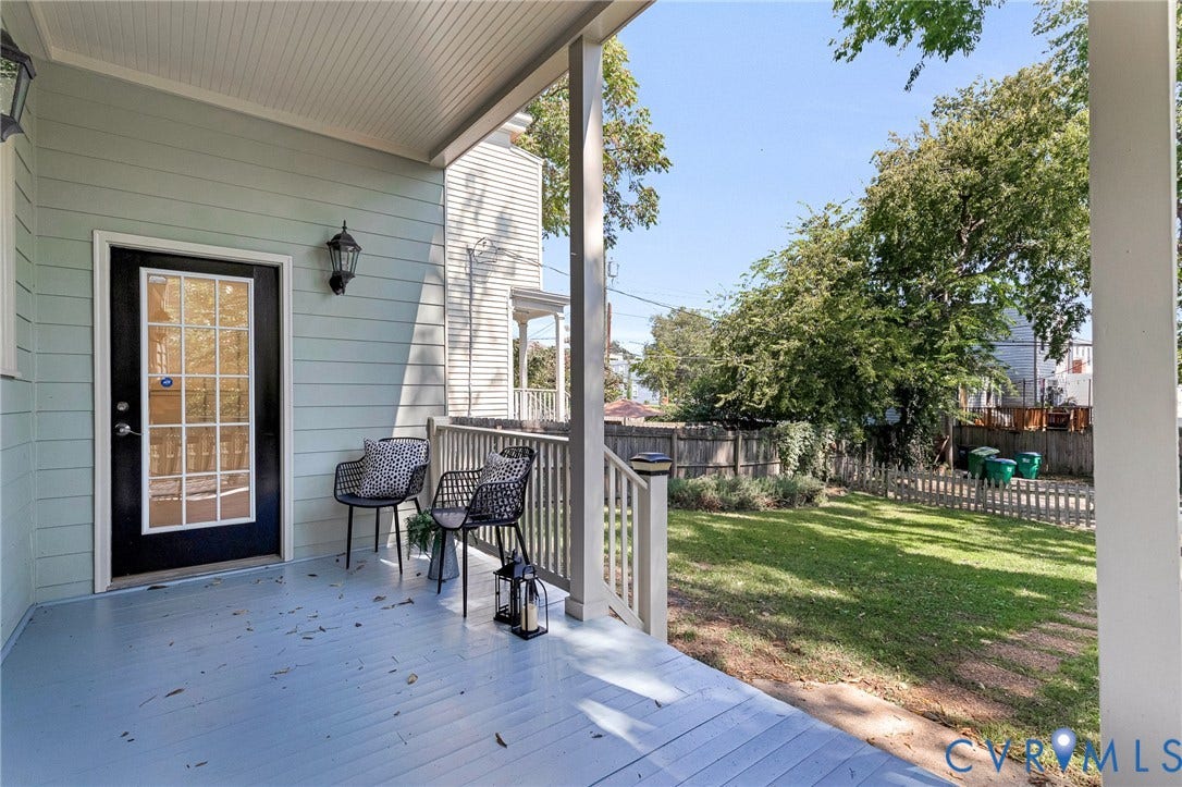 615 N 23rd Street, Church Hill Central, Richmond, VA 23223 Shaded front porch with beadboard ceiling, light blue siding, and a glass-paneled entry door