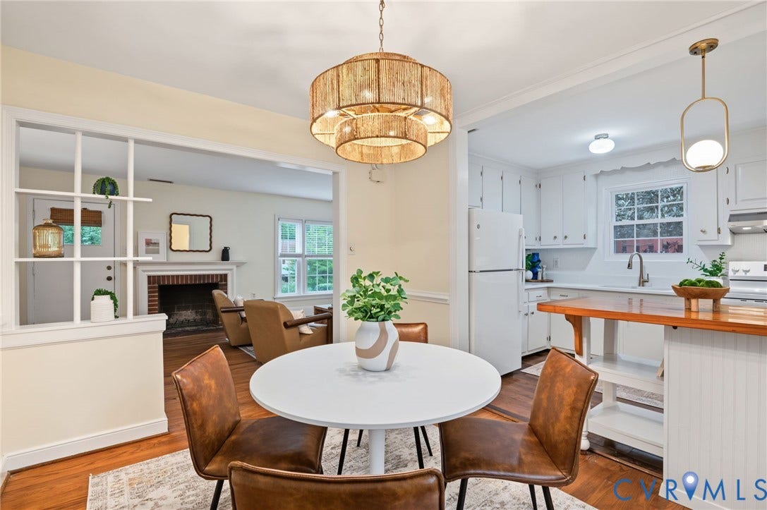 3353 Warner Road, Stratford Hills, Richmond, VA 23225 Dining area with a tiered woven chandelier, wood-finish flooring, and an open pass-through to the kitchen featuring white cabinetry and a wood-finish island countertop