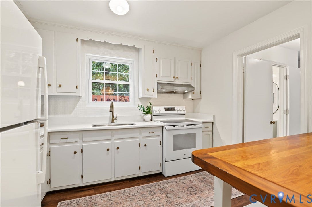 3353 Warner Road, Stratford Hills, Richmond, VA 23225 White cabinetry with brass-tone hardware, white countertop surfaces, stainless steel sink with a gooseneck faucet, and wood-finish flooring