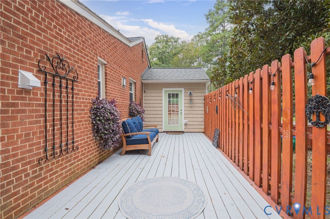 3353 Warner Road, Stratford Hills, Richmond, VA 23225 Expansive wood-finish deck with a painted surface, surrounded by a wood fence, and featuring a brick exterior wall