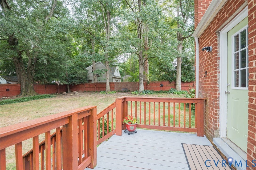 3353 Warner Road, Stratford Hills, Richmond, VA 23225 Brick exterior featuring a wood deck with a light-colored finish, wood railings, and a fenced backyard with mature trees