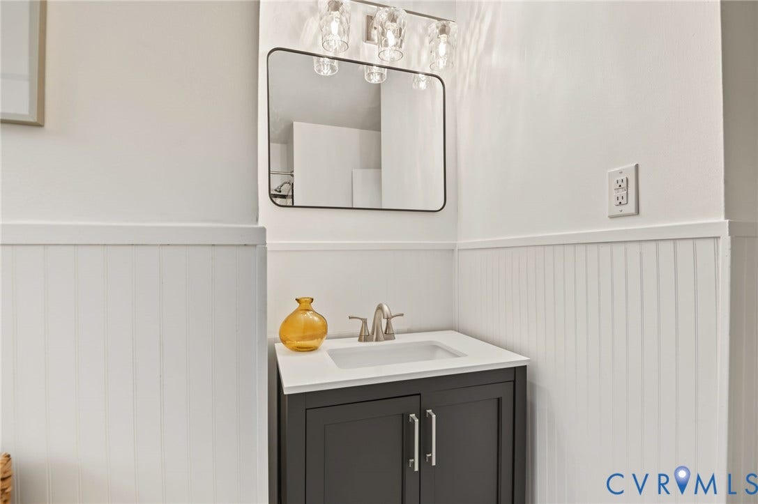 3353 Warner Road, Stratford Hills, Richmond, VA 23225 Wall-mounted vanity mirror, modern light fixture, integrated sink, brushed nickel faucet, beadboard wainscoting