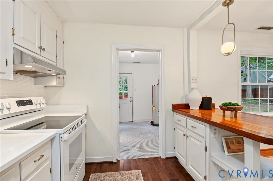 3353 Warner Road, Stratford Hills, Richmond, VA 23225 White cabinetry with brass hardware, wood-finish flooring, white solid surface countertops, white electric range with range hood, and a wood-finish bar top with integrated storage