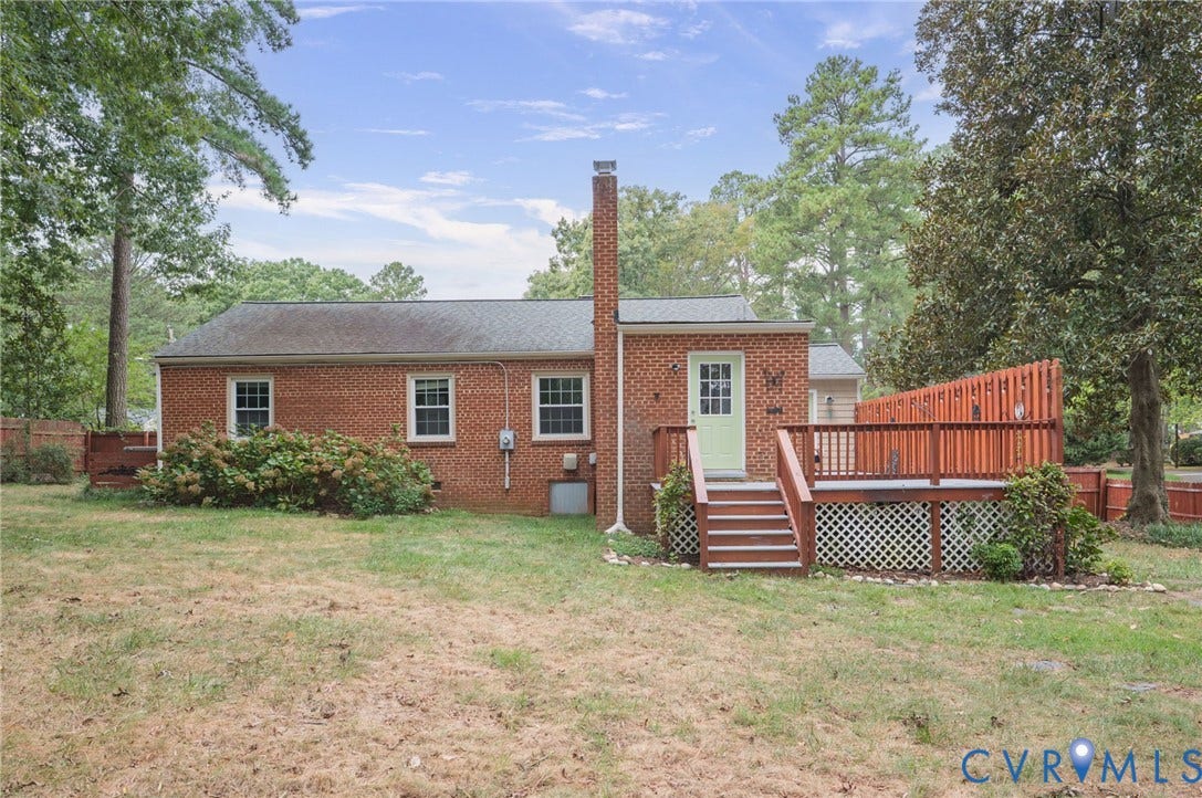 3353 Warner Road, Stratford Hills, Richmond, VA 23225 Brick exterior with multiple windows, an exterior chimney, a wooden deck, and a fenced perimeter