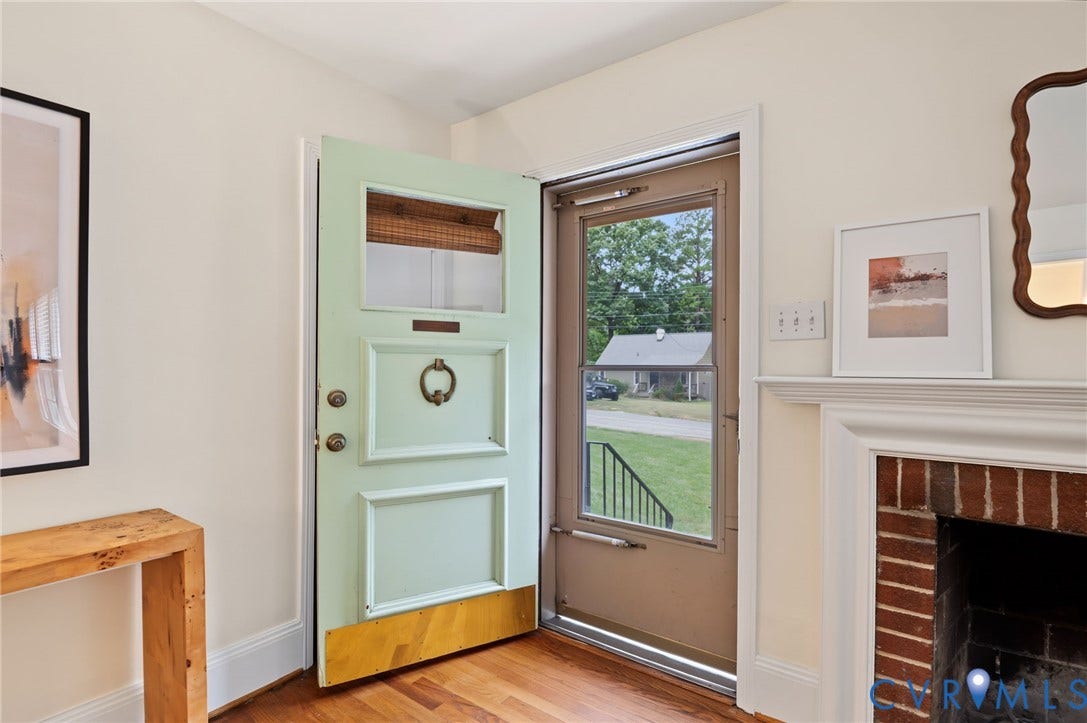 3353 Warner Road, Stratford Hills, Richmond, VA 23225 Hardwood flooring, painted interior door, fireplace with brick surround, white mantel, and framed glass storm door