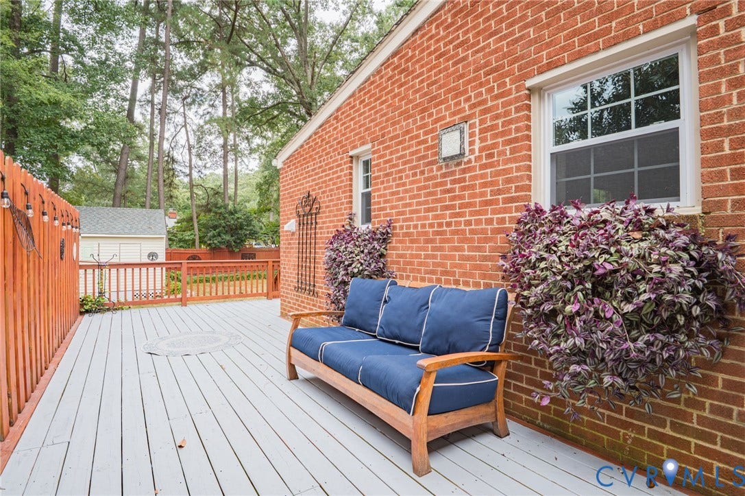 3353 Warner Road, Stratford Hills, Richmond, VA 23225 Expansive wood-finish deck with a painted surface, surrounded by a wood fence, and featuring a brick exterior wall