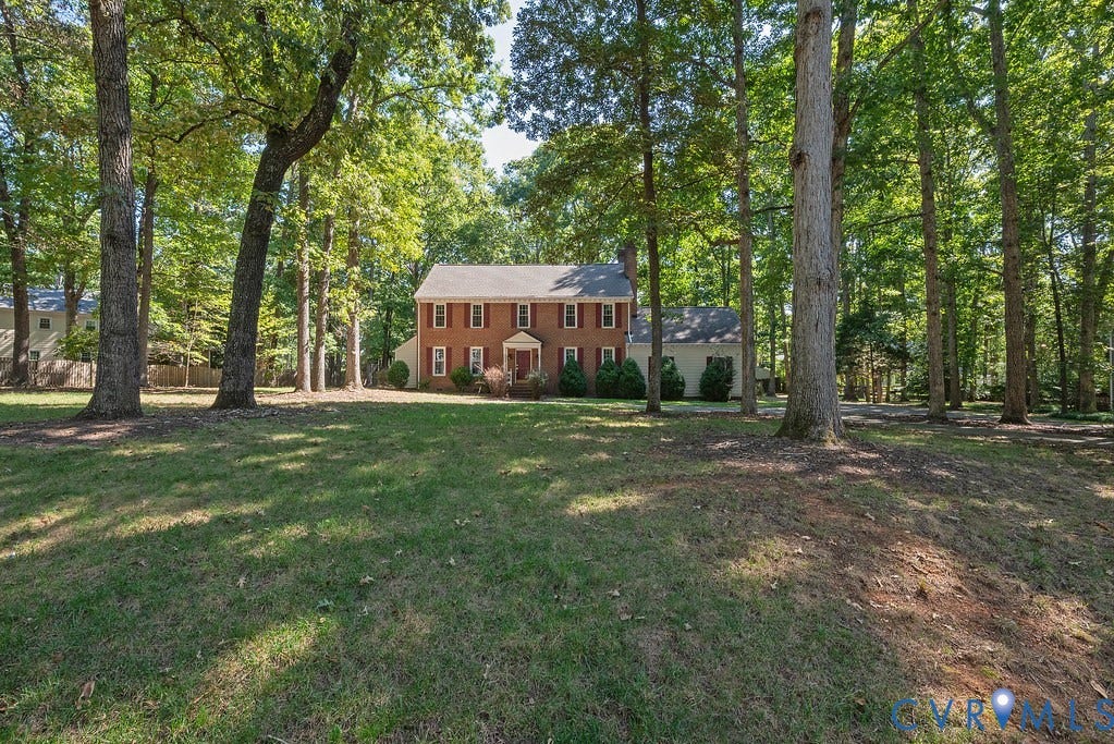 13830 Hailsham Circle, Salisbury, Midlothian, VA 23113 Brick exterior residence with a gabled roof, surrounded by mature trees, set on a grassy lot