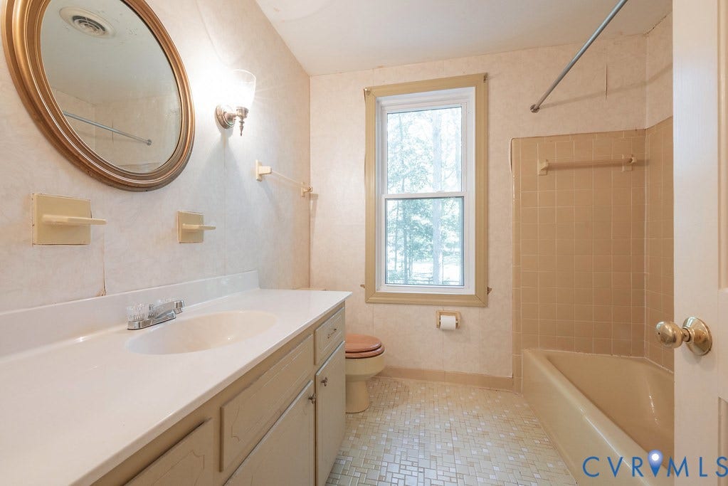13830 Hailsham Circle, Salisbury, Midlothian, VA 23113 Vanity with integrated sink, coordinating wall sconce, framed mirror, tiled flooring, and a bath/shower combination