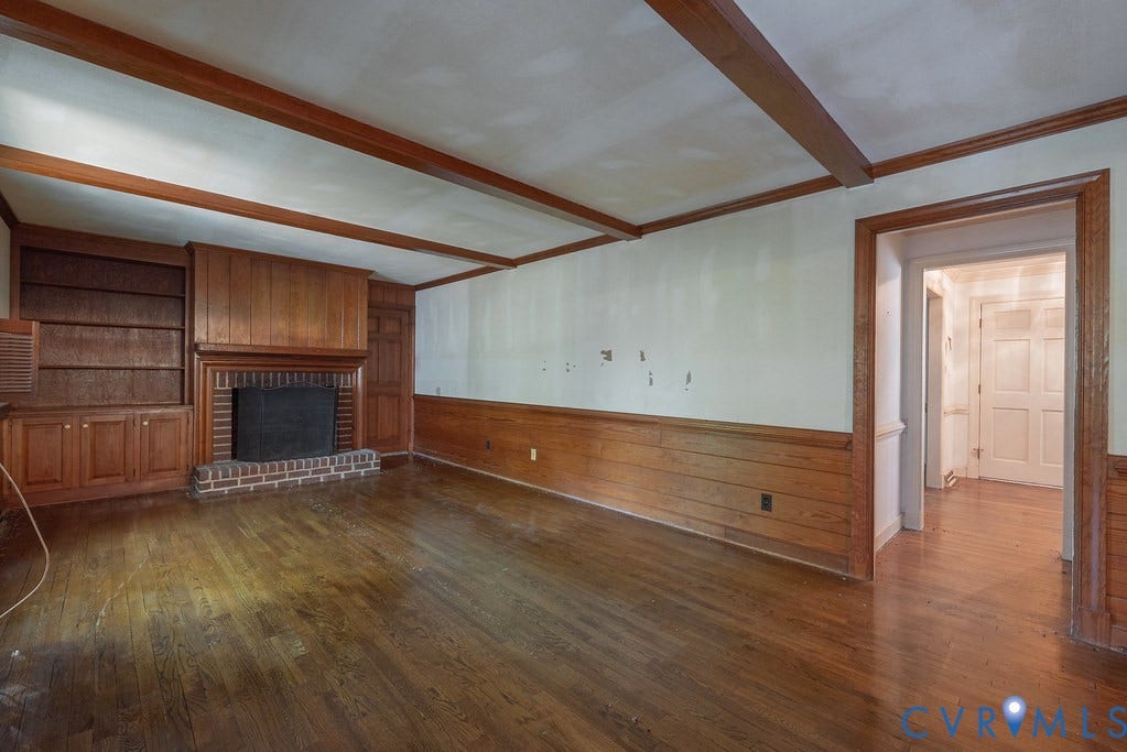 13830 Hailsham Circle, Salisbury, Midlothian, VA 23113 Hardwood flooring throughout, exposed wood ceiling beams, brick fireplace with wood mantel, built-in wood shelving, and wood wainscoting