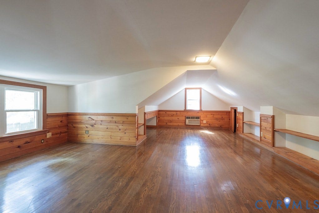 13830 Hailsham Circle, Salisbury, Midlothian, VA 23113 Spacious room featuring wood-finish flooring, wood paneling, two windows, built-in shelving, and a sloped ceiling
