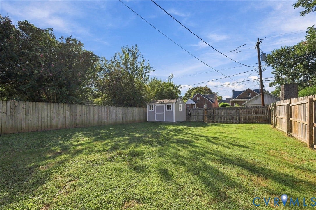 3504 Delaware Avenue, Richmond, VA 23222 Expansive backyard featuring a manicured lawn, full perimeter wood fencing, and a detached storage shed