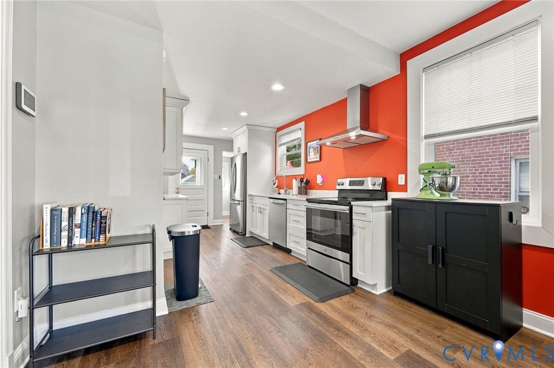 3504 Delaware Avenue, Richmond, VA 23222 Modern kitchen with stainless steel appliances, white cabinetry, wood-finish flooring, and a stainless steel range hood