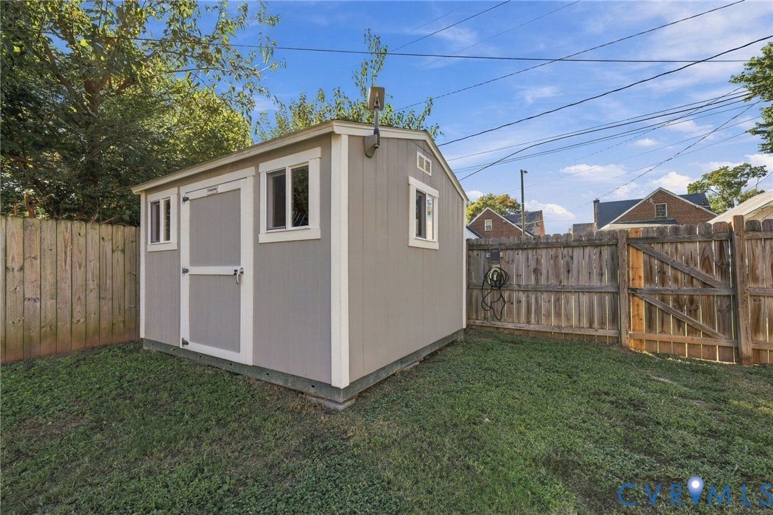 3504 Delaware Avenue, Richmond, VA 23222 Detached storage shed with two windows, a single entry door, and a wood privacy fence