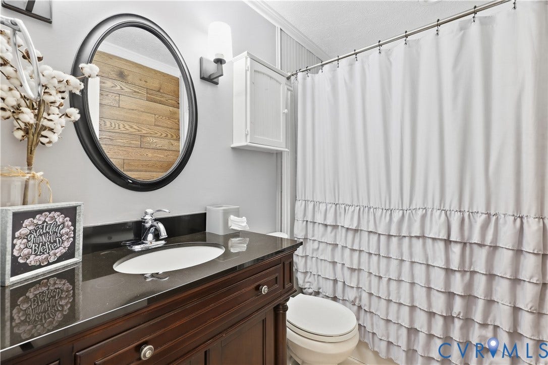 Dark wood-finish vanity with an oval undermount sink and a dark countertop