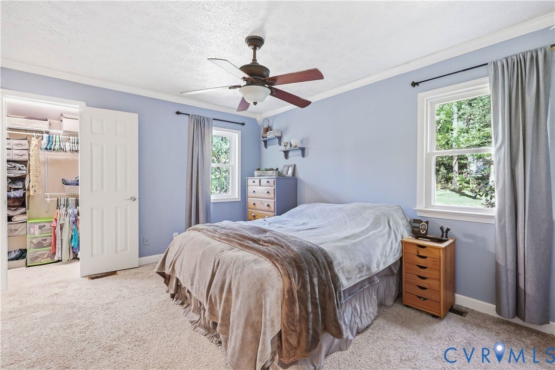 Wall-to-wall carpeting, crown molding, and a ceiling fan with integrated lighting