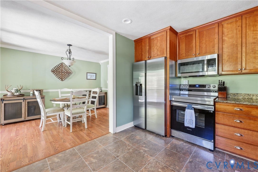 Kitchen featuring stainless steel appliances, wood cabinetry, and tiled flooring