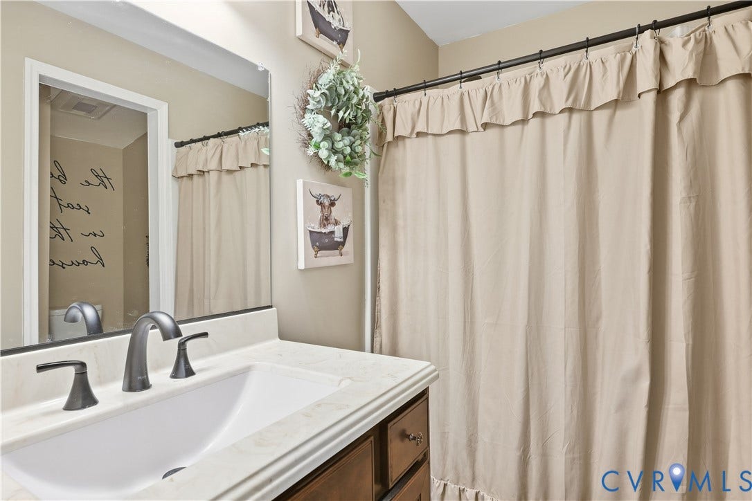 Vanity with integrated sink, dark bronze faucet, and light-toned countertop