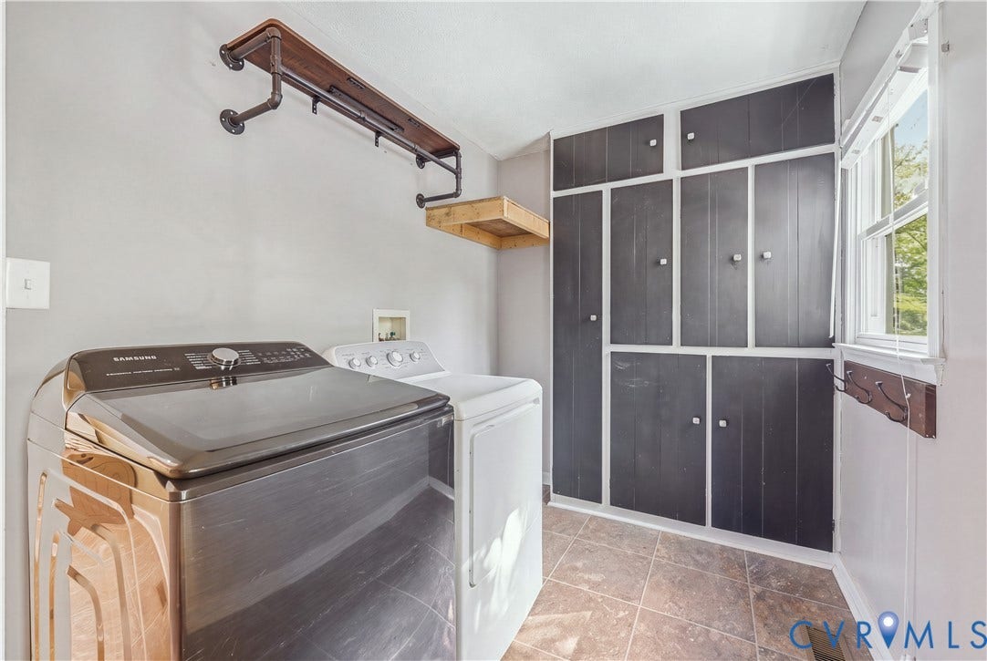Built-in storage cabinetry, tiled flooring, window with natural light, and a wall-mounted shelf with pipe supports