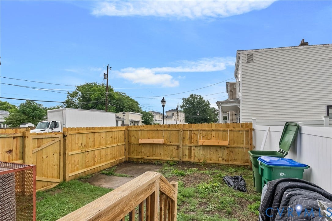Private backyard featuring a new wood fence and a small patch of grass