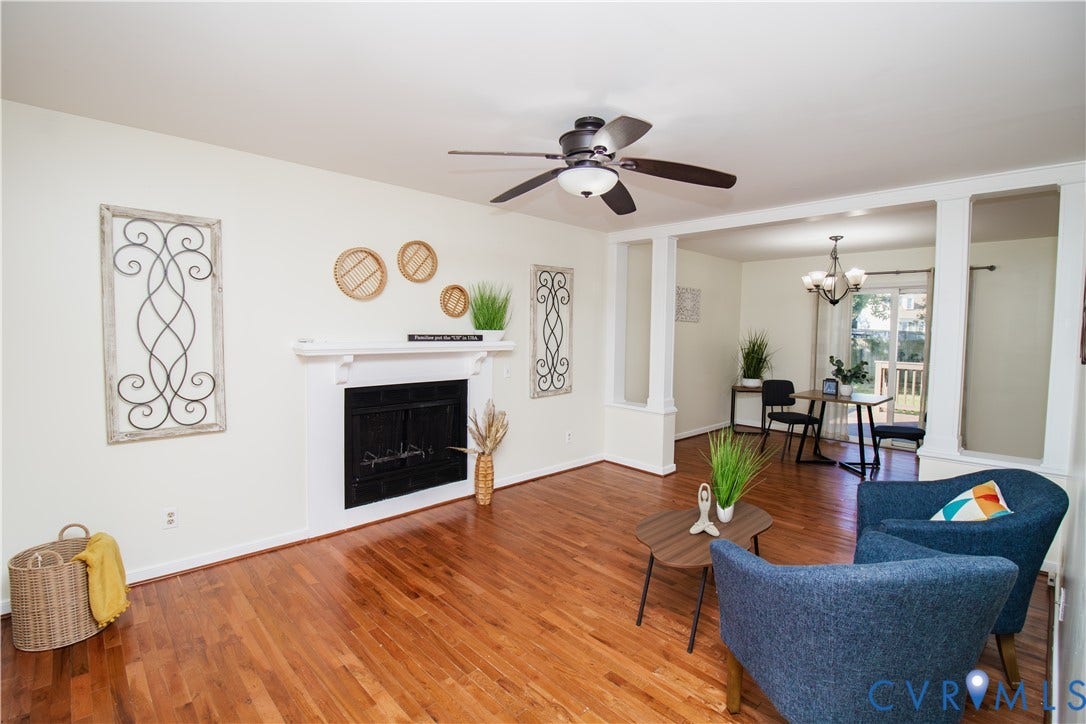 1307 Berrymeade Avenue, Henrico, VA 23060 Hardwood flooring, fireplace with white mantel, ceiling fan with light, white wall finishes, and a framed opening to an adjacent room