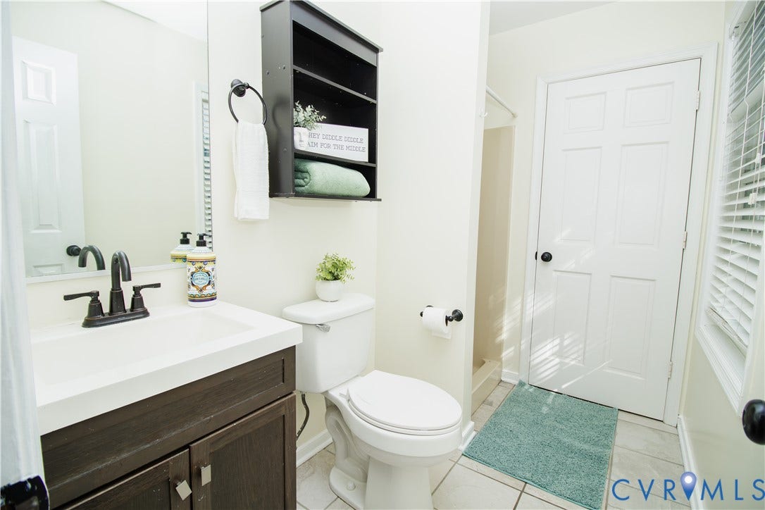 1307 Berrymeade Avenue, Henrico, VA 23060 Bathroom featuring a dark wood-finish vanity with a white countertop and integrated sink, bronze-finish faucet, and tile flooring