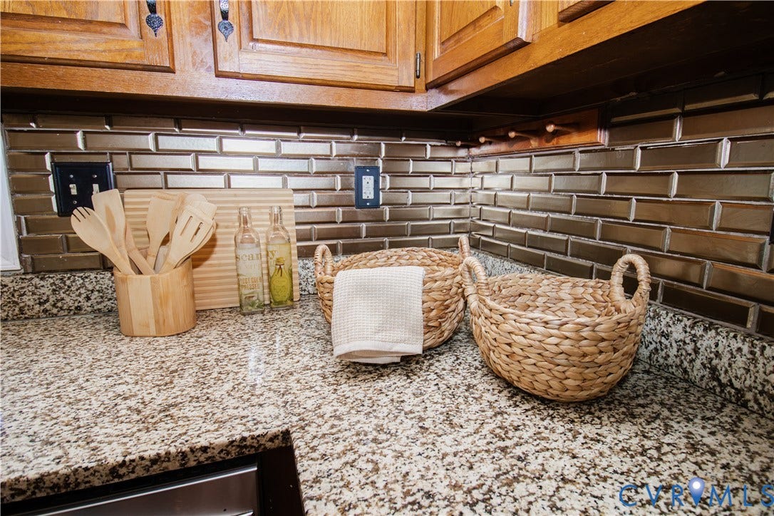 1307 Berrymeade Avenue, Henrico, VA 23060 Granite-finish countertops, wood cabinetry, and a subway tile backsplash