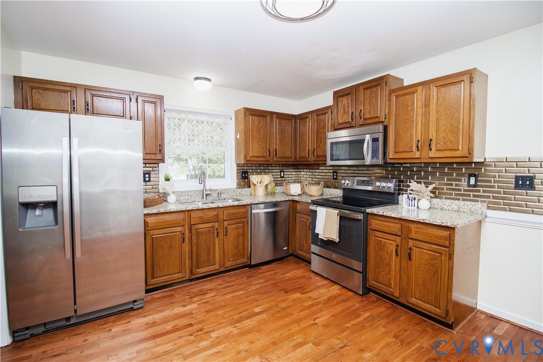 1307 Berrymeade Avenue, Henrico, VA 23060 Kitchen featuring wood-finish flooring, granite-style countertops, stainless steel appliances, wood cabinetry, and a tile backsplash