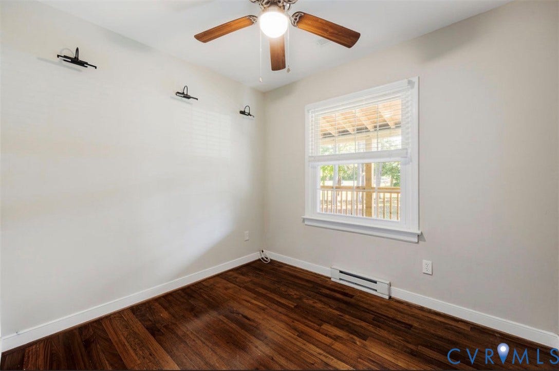 Hardwood-finish flooring, white trim, and a window with blinds