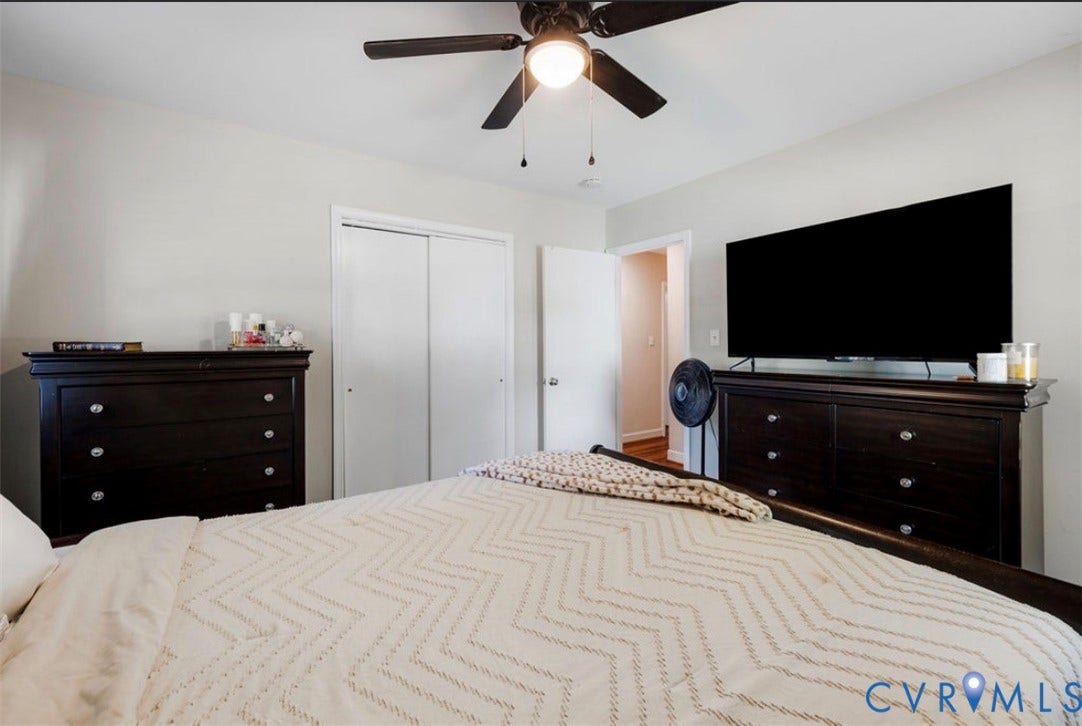 Room with a ceiling fan, white walls, and wood-finish flooring