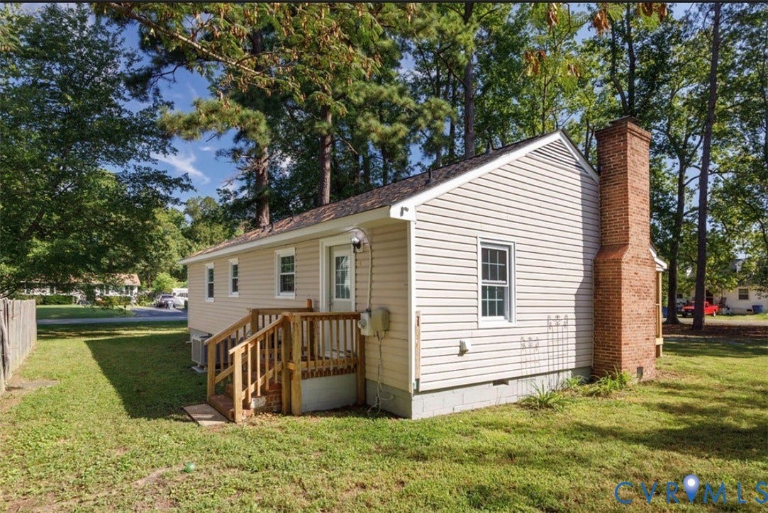 Siding exterior with a brick chimney and a wood deck