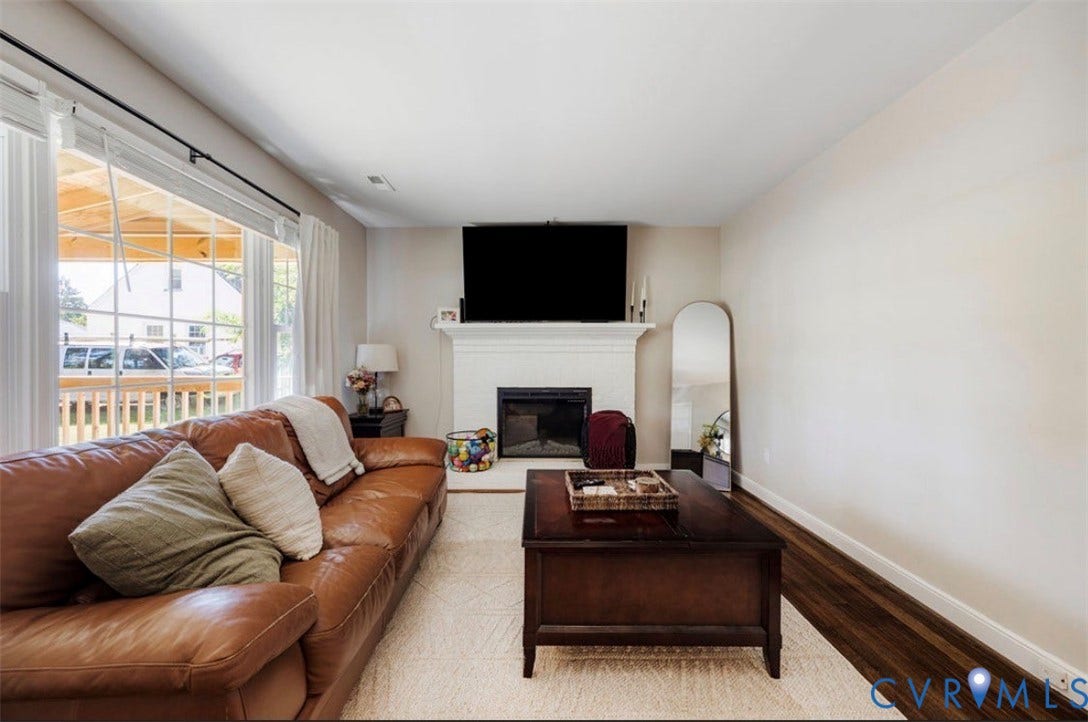 Living space with a large window, fireplace, and dark wood-finish flooring