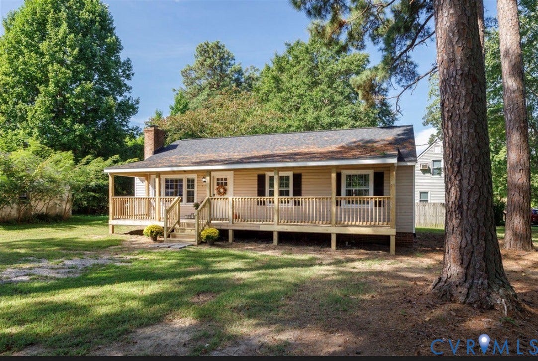 Siding exterior with a covered front porch, dark shingled roof, and a visible chimney