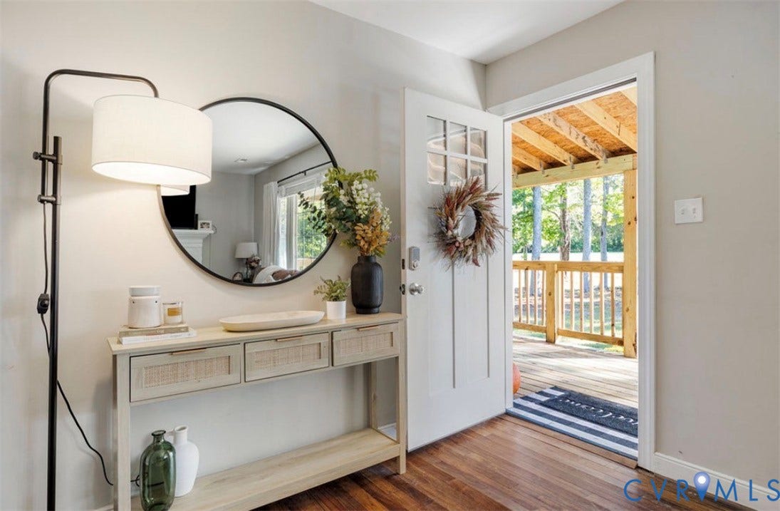 Wood-finish flooring, light gray wall paint, and a built-in console table with storage
