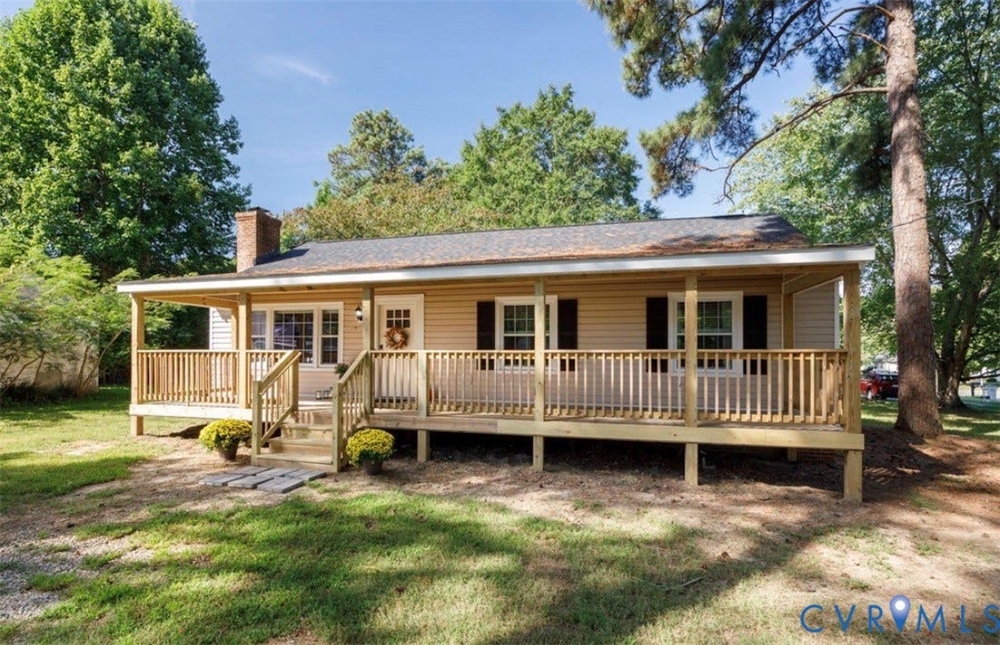 Inviting covered front porch with natural wood railing and steps
