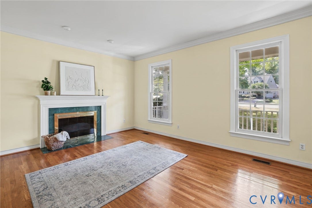 3600 Rivermist Terrace, Midlothian, VA 23113 Hardwood flooring throughout, featuring a fireplace with a white mantel and green surround, and two windows with white trim