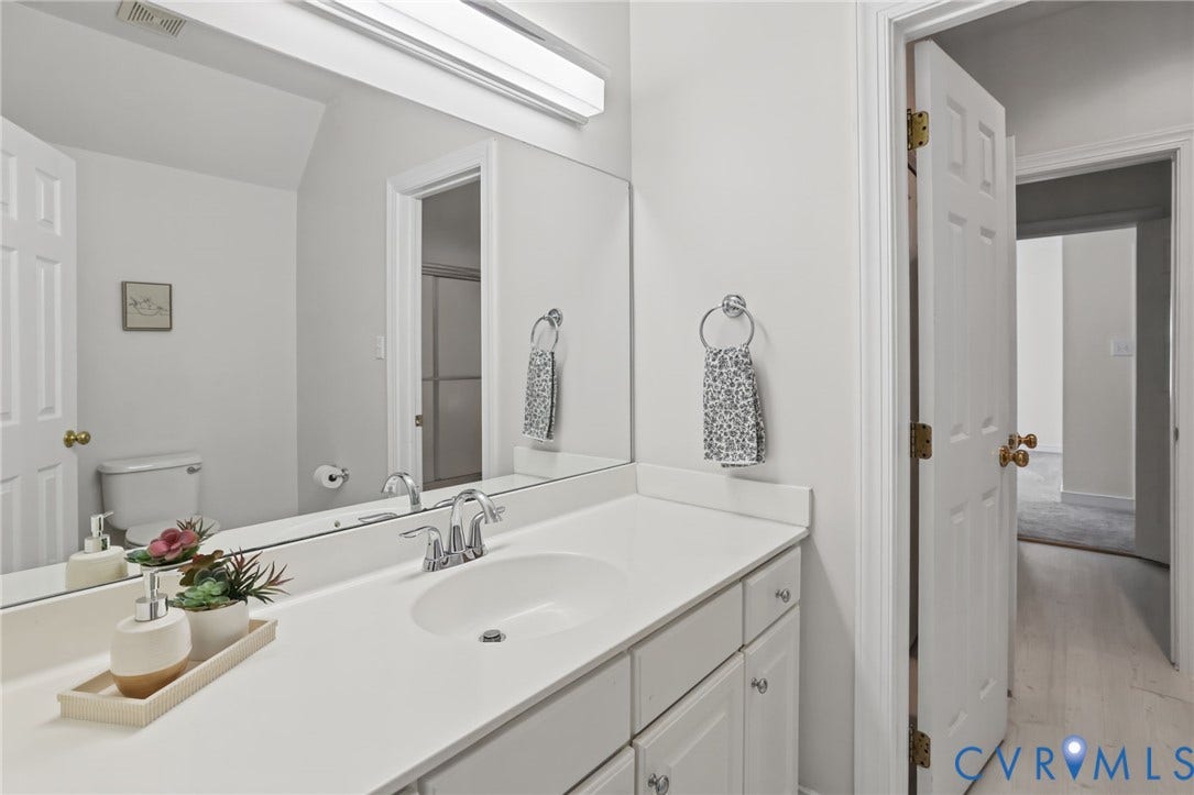 3600 Rivermist Terrace, Midlothian, VA 23113 White vanity with a single basin sink, chrome faucet, and a large wall-mounted mirror