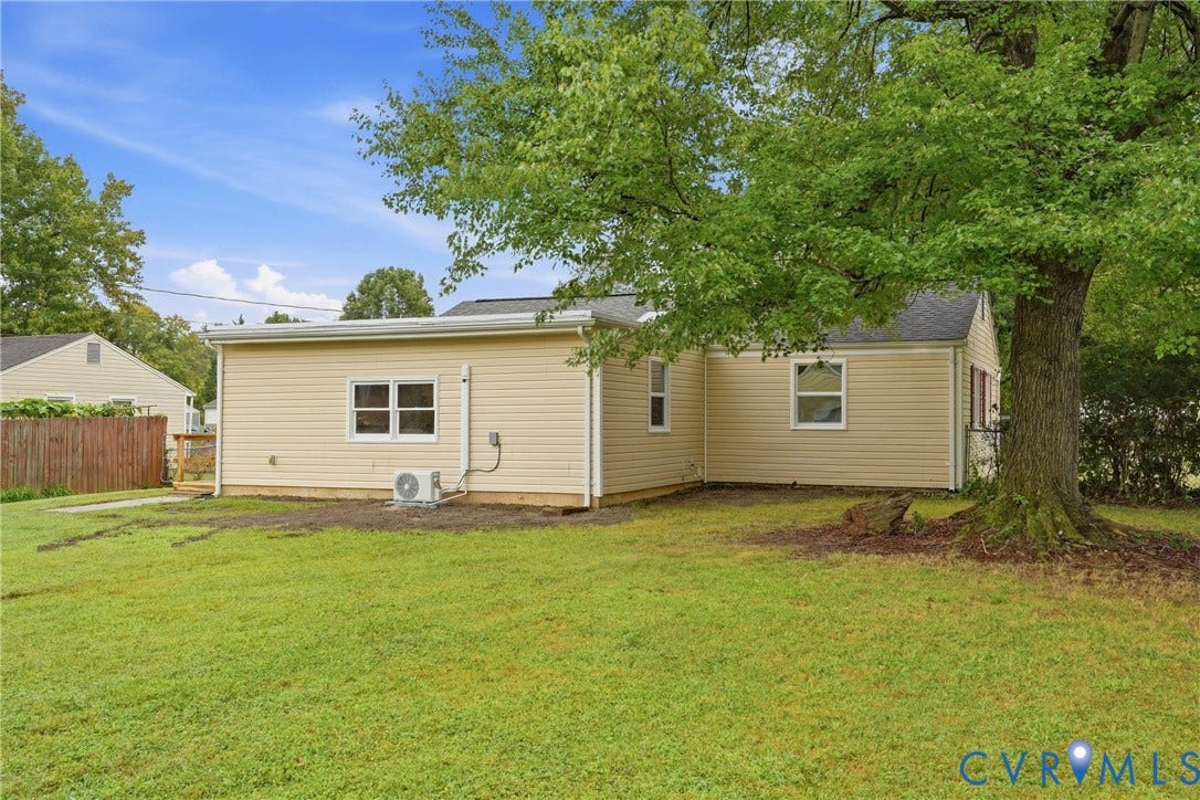 1814 Aeronca Avenue, Henrico, VA 23228 Expansive lawn area, mature trees, tan siding, multiple windows, and a wood privacy fence