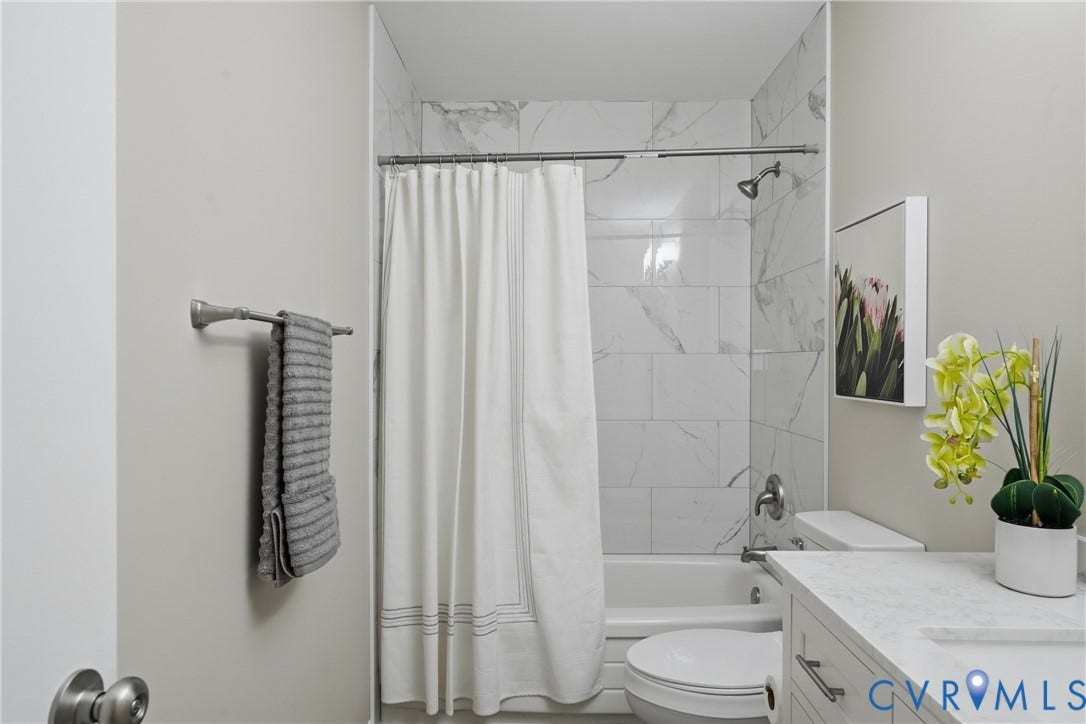 1814 Aeronca Avenue, Henrico, VA 23228 Modern bathroom featuring a frameless glass-enclosed shower with marble-look tile surround, white subway tile walls, and chrome fixtures