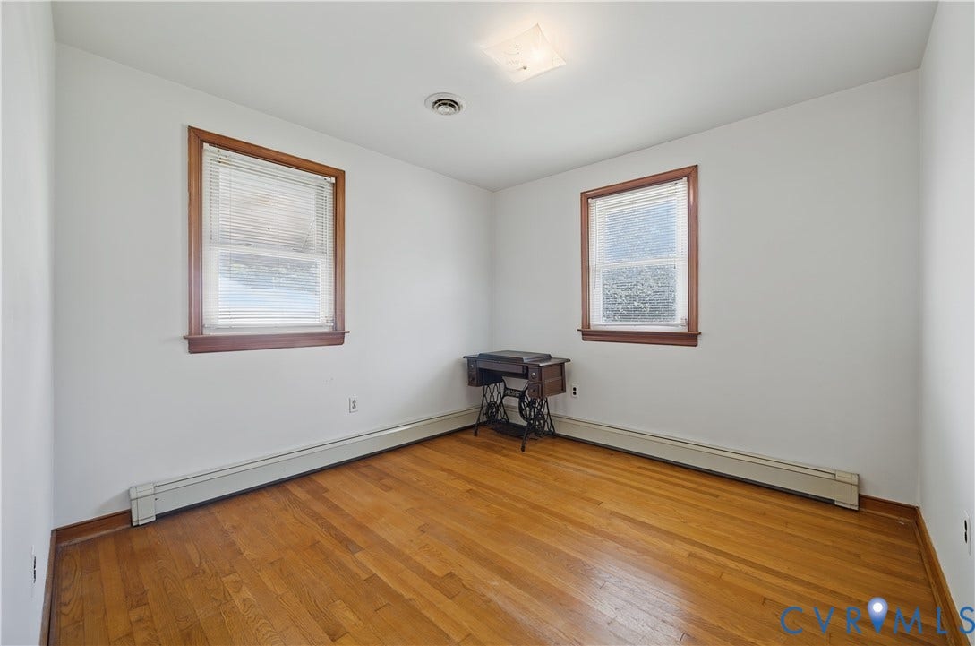 528 Duffton Road, Richmond, VA 23225 Bright corner room featuring gleaming hardwood flooring, two large double-hung windows with wood trim framing natural light, and clean white walls
