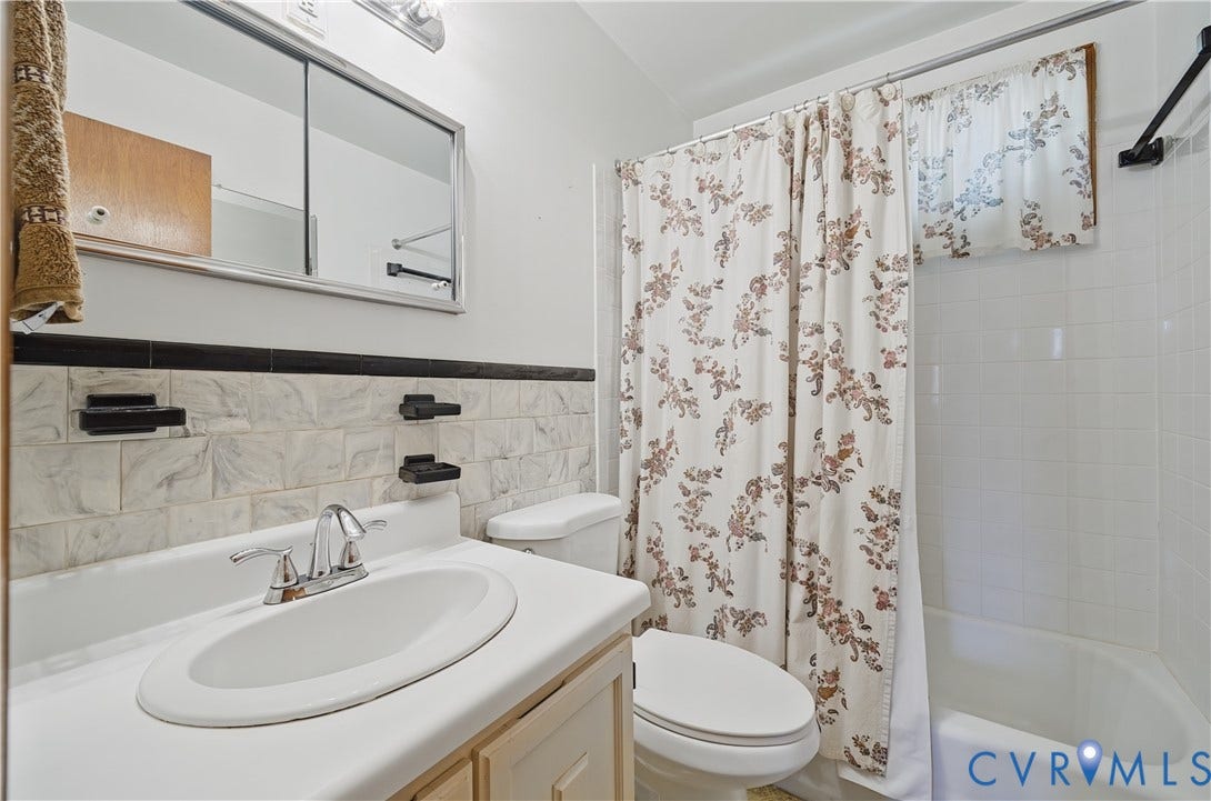 528 Duffton Road, Richmond, VA 23225 Bathroom featuring a wall-mounted medicine cabinet, white tiled bathtub surround, and a vanity with a drop-in sink