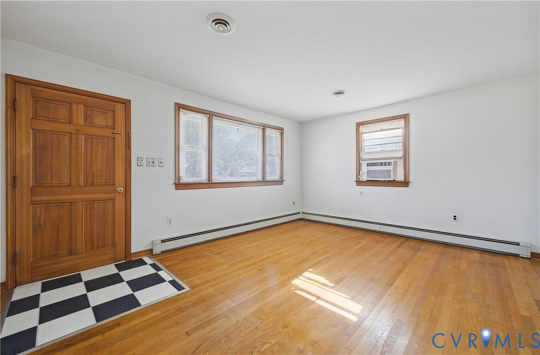 528 Duffton Road, Richmond, VA 23225 Hardwood flooring, wood panel door, multiple windows, window air conditioning unit, and white walls
