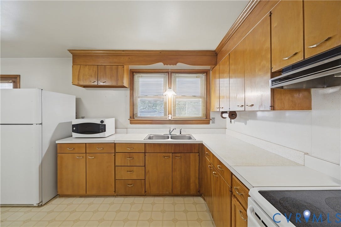 528 Duffton Road, Richmond, VA 23225 U-shaped kitchen layout with wood-finish cabinetry, white countertops, a double basin sink, and a built-in range hood