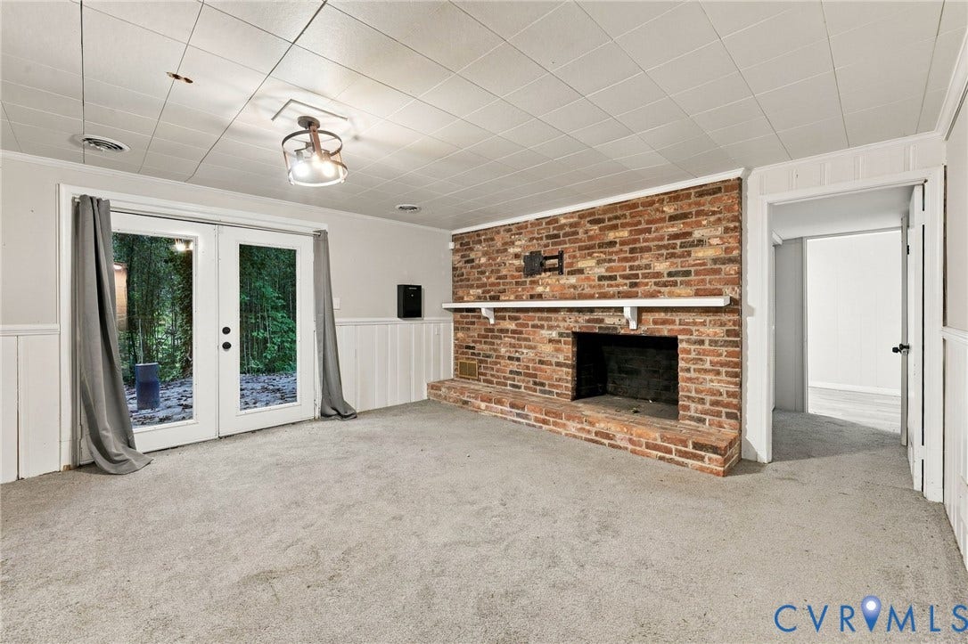 3238 E Weyburn Road, Bon Air, Richmond, VA 23235 Brick fireplace with a white mantel, double glass panel doors, and wainscoting